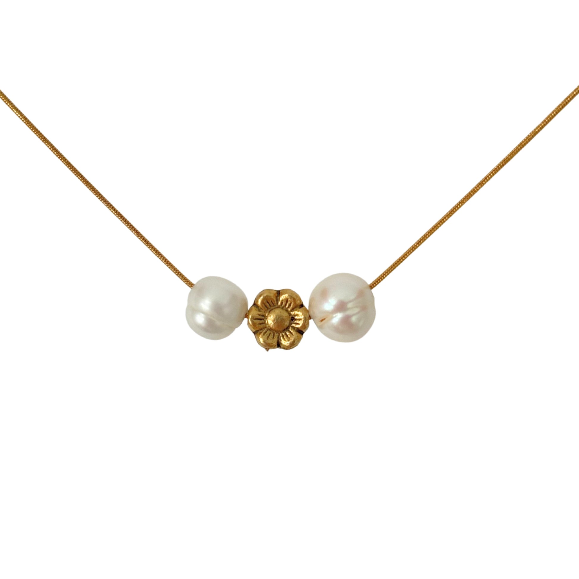 Close-up of pearl and gold flower charm