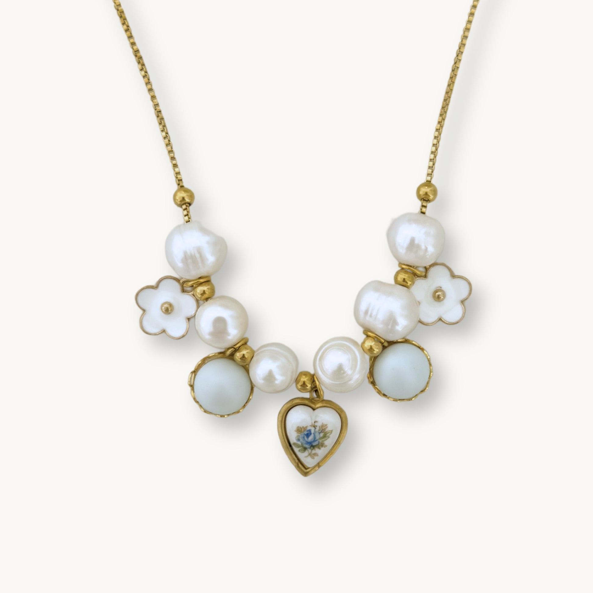 Close-up of the Freya Necklace showcasing its detailed design with pearls, a floral charm, and a blue rose heart ceramic pendant.