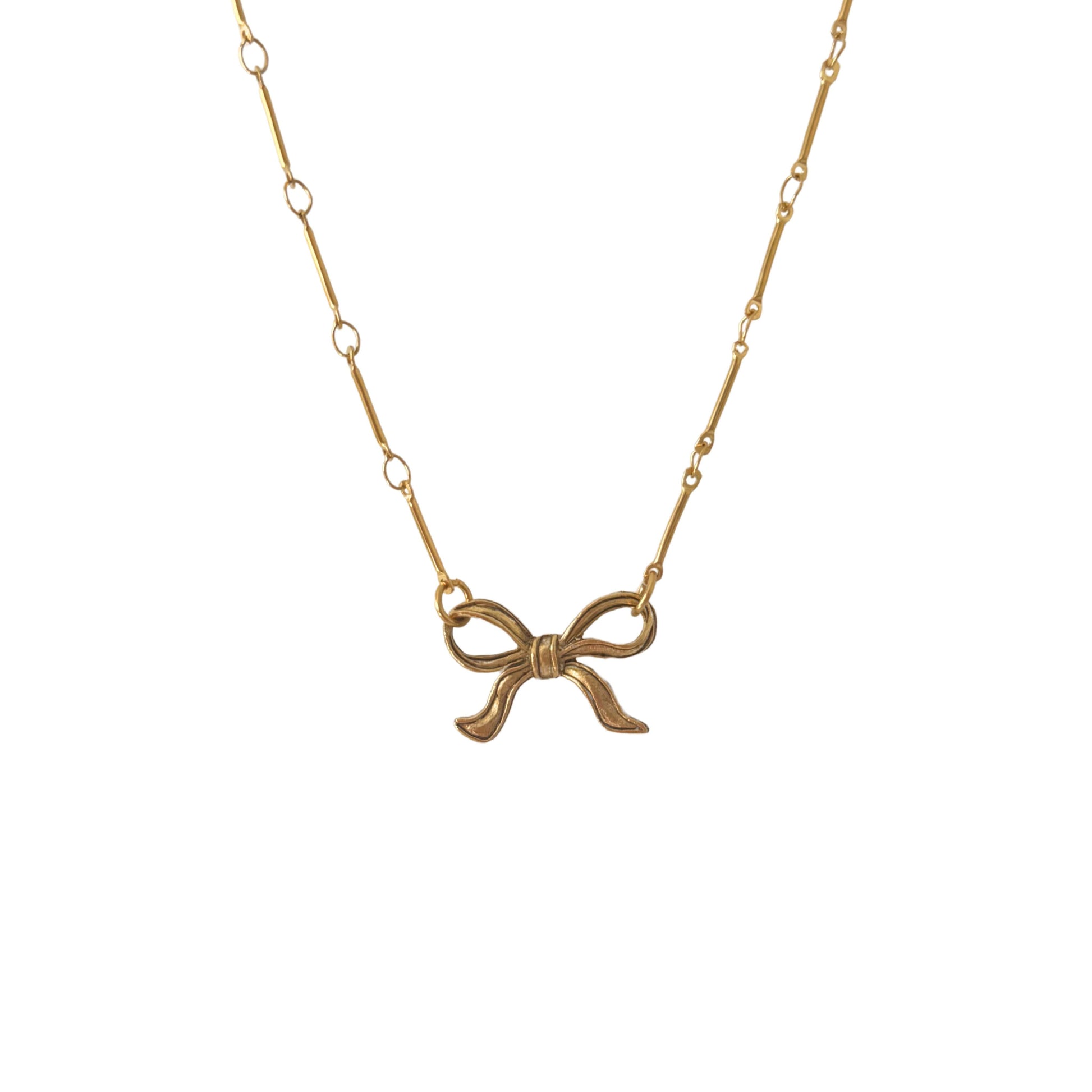 Close-up of the Tullah Necklace styled with a minimalist outfit, showing the elegant bow charm
