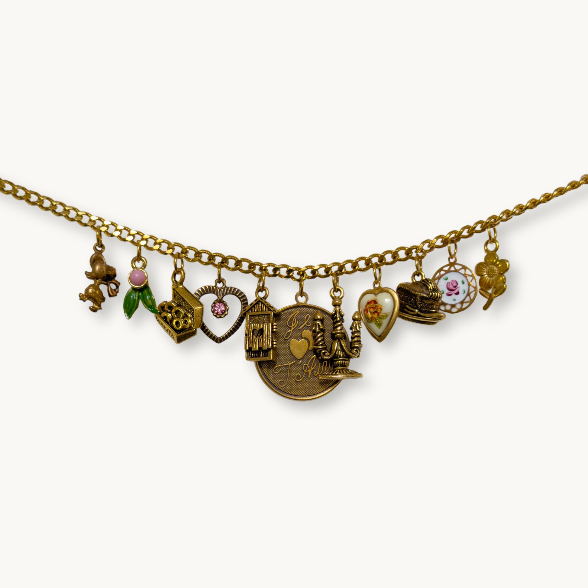 Close-up of the Willow Necklace with ‘Je T’aime’ pendant and whimsical vintage charms.