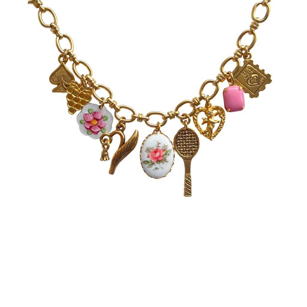 Close-up of gold-plated charms and pink stone details
