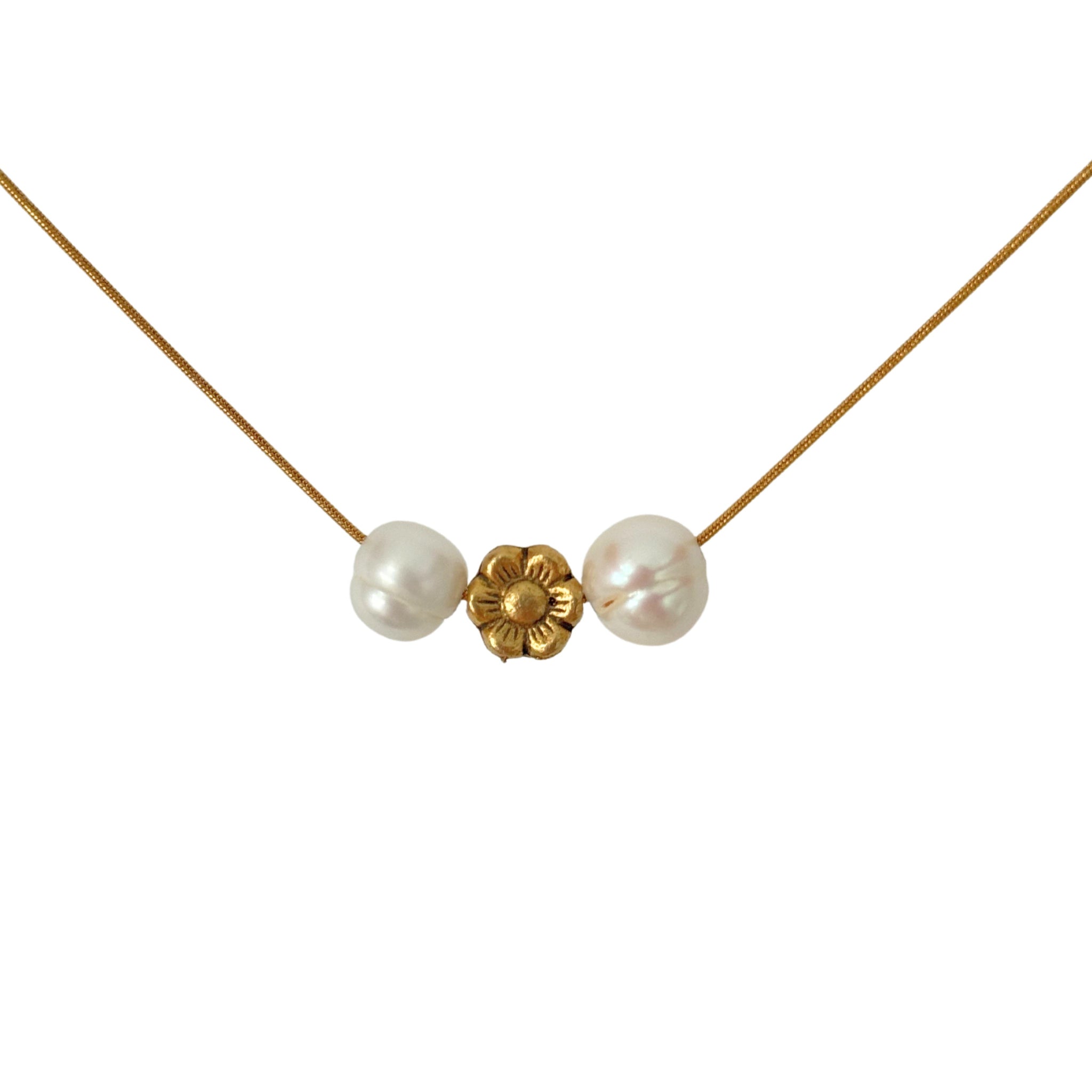 Close-up of pearl and gold flower charm