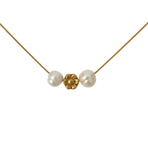 Close-up of pearl and gold flower charm