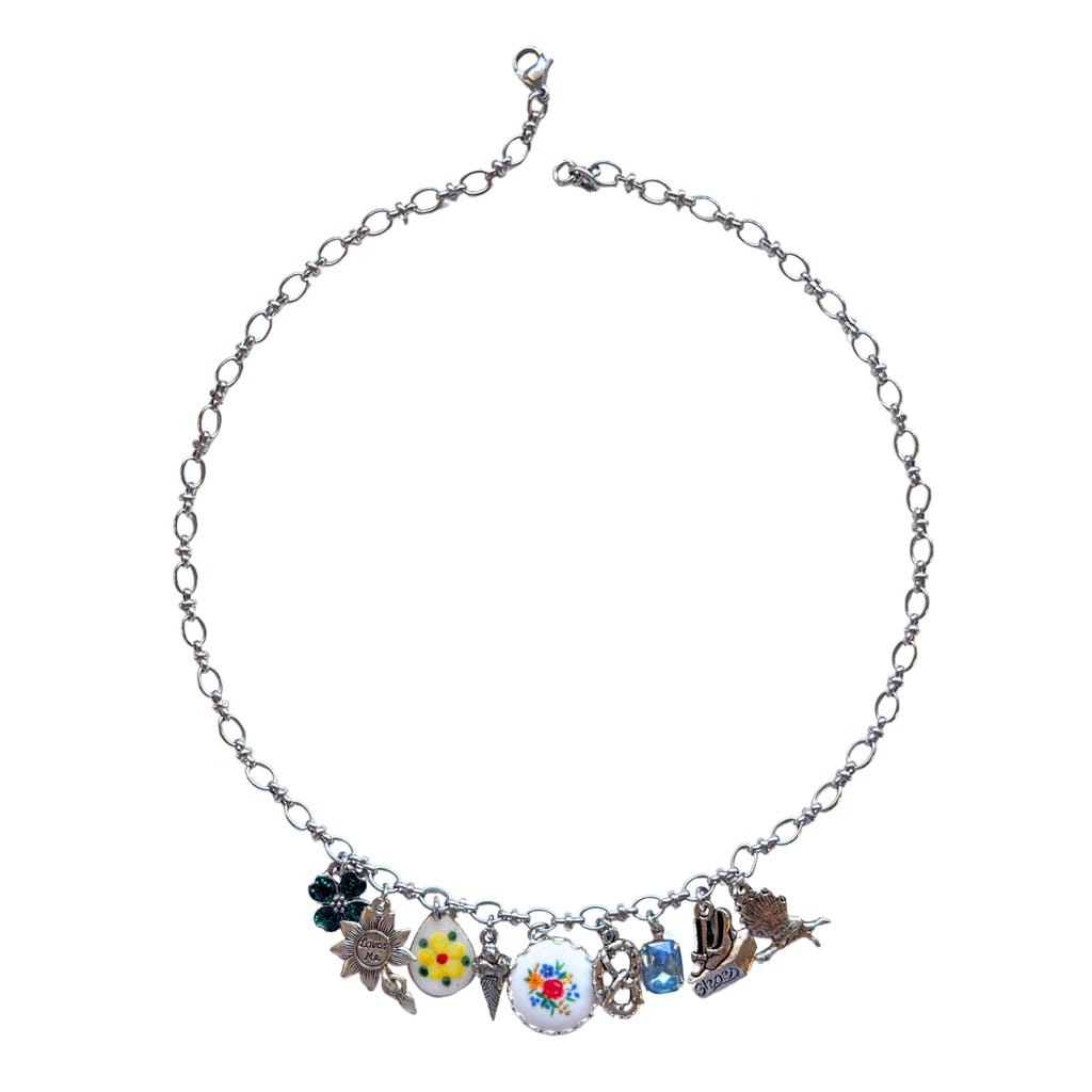 Anya Necklace flatlay showing colorful floral and playful charms