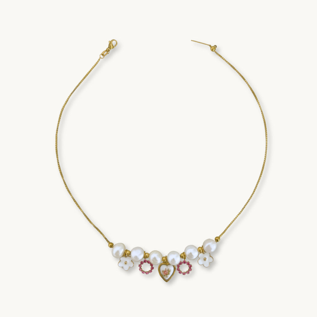 Aria Necklace - 18K gold-plated box chain with baroque pearls, white flowers, an Austrian rhinestone, and a pink floral heart pendant set on brass, 17 inches in length.