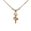Close-up of ballerina charm and freshwater pearls