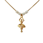 Close-up of ballerina charm and freshwater pearls