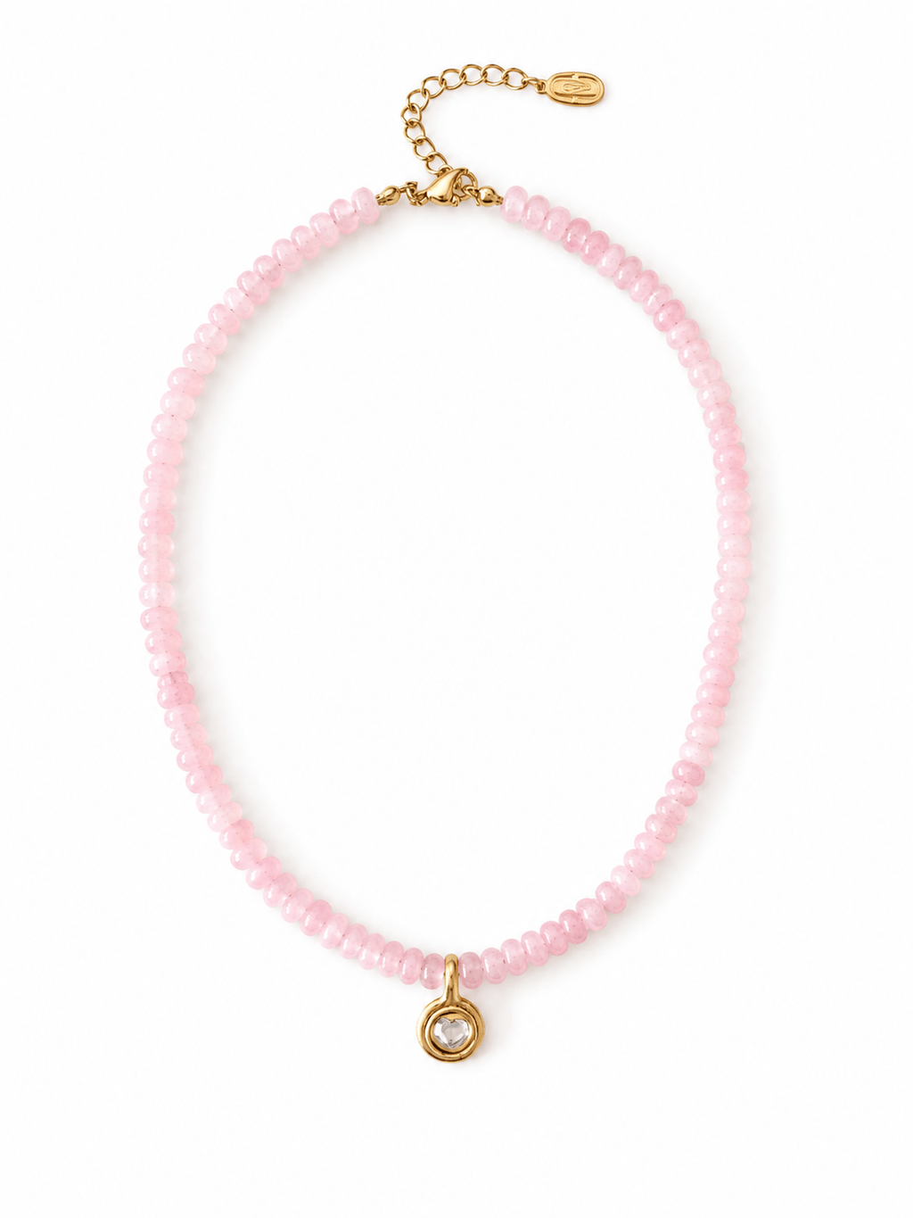 A delicate pink beaded necklace with a small gold pendant featuring a clear faceted gemstone, displayed on a clean white background.