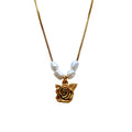 Close-up of shabby English rose pendant and freshwater pearls