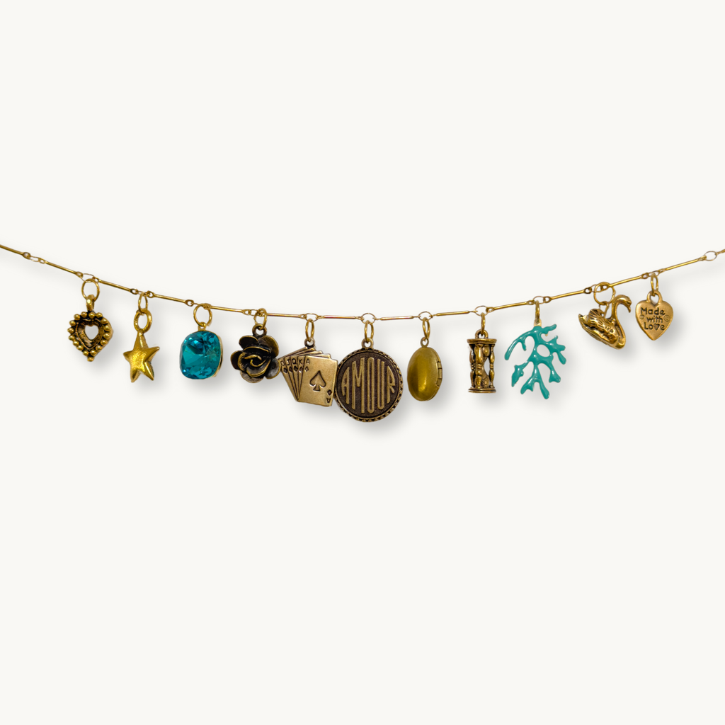 Close-up of the Ellie Necklace showcasing its antique locket and delicate charms.