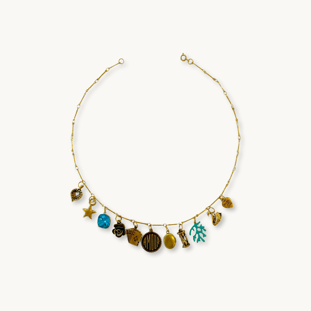 Ellie Necklace featuring an Isabella dainty chain with 11 vintage and modern charms, including a patina oval locket.