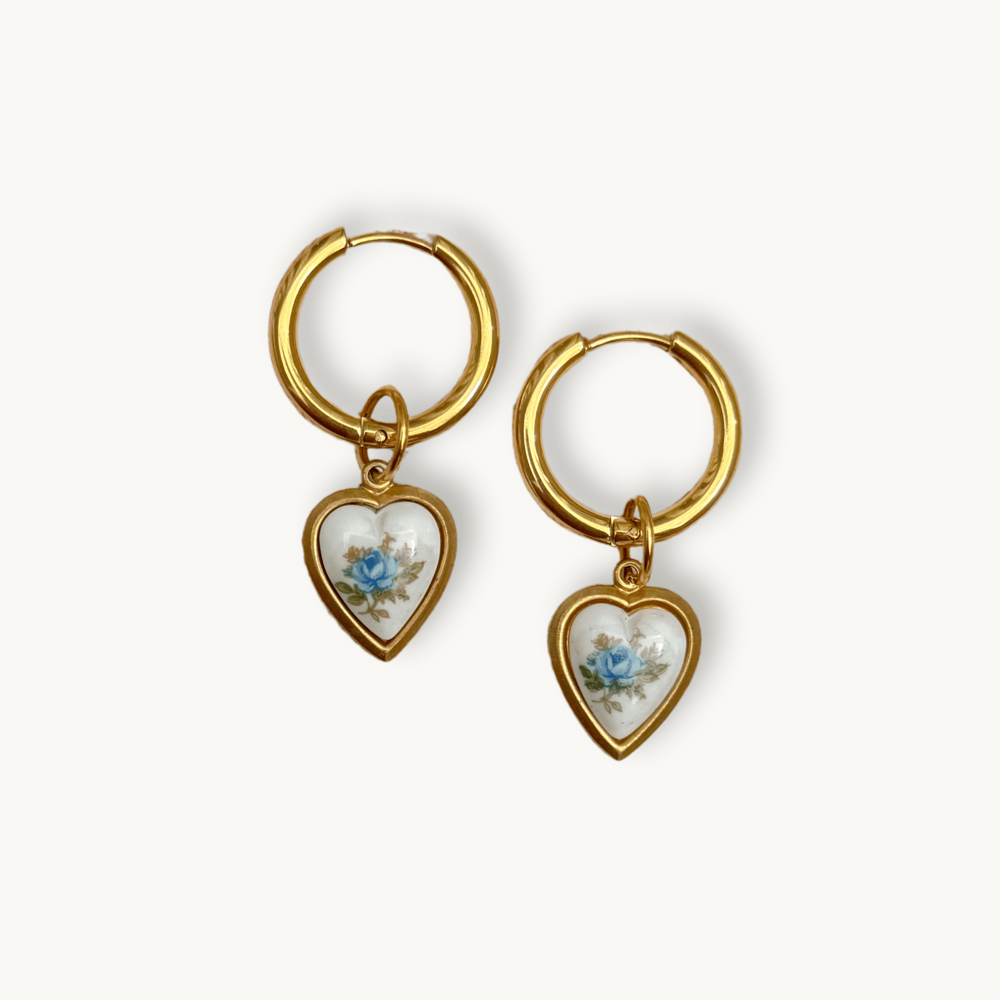 Close-up of gold huggie hoops and heart charm