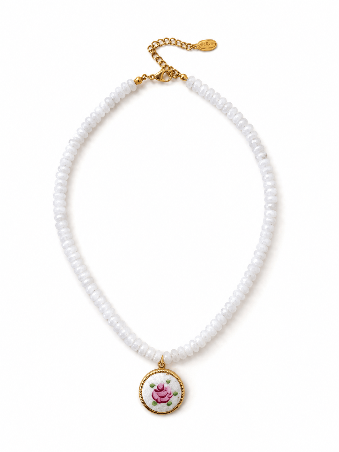 A white beaded necklace with a gold-tone chain extender and a round pendant featuring a pink rose on a white background with green leaves.