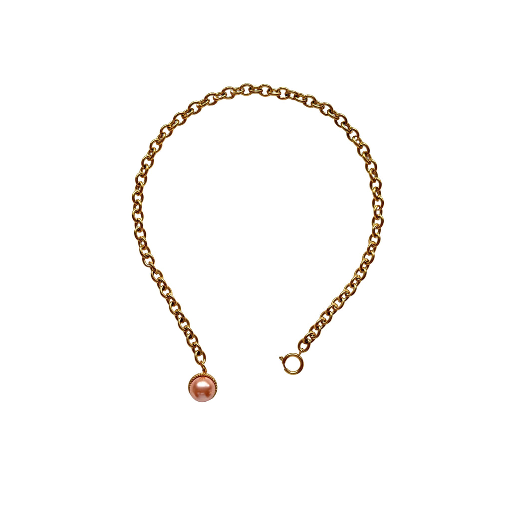 Close-up of Esmeralda’s pearl pendant and chunky spring lock