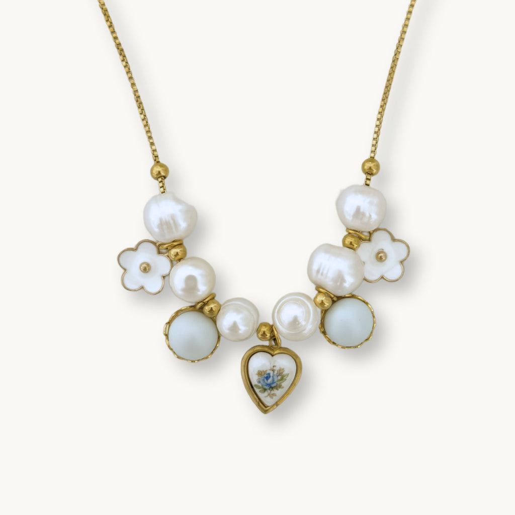 Close-up of the Freya Necklace showcasing its detailed design with pearls, a floral charm, and a blue rose heart ceramic pendant.