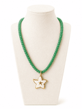 A green beaded necklace with a white enamel star pendant outlined in gold, displayed on a cream-colored jewelry bust against a white background.