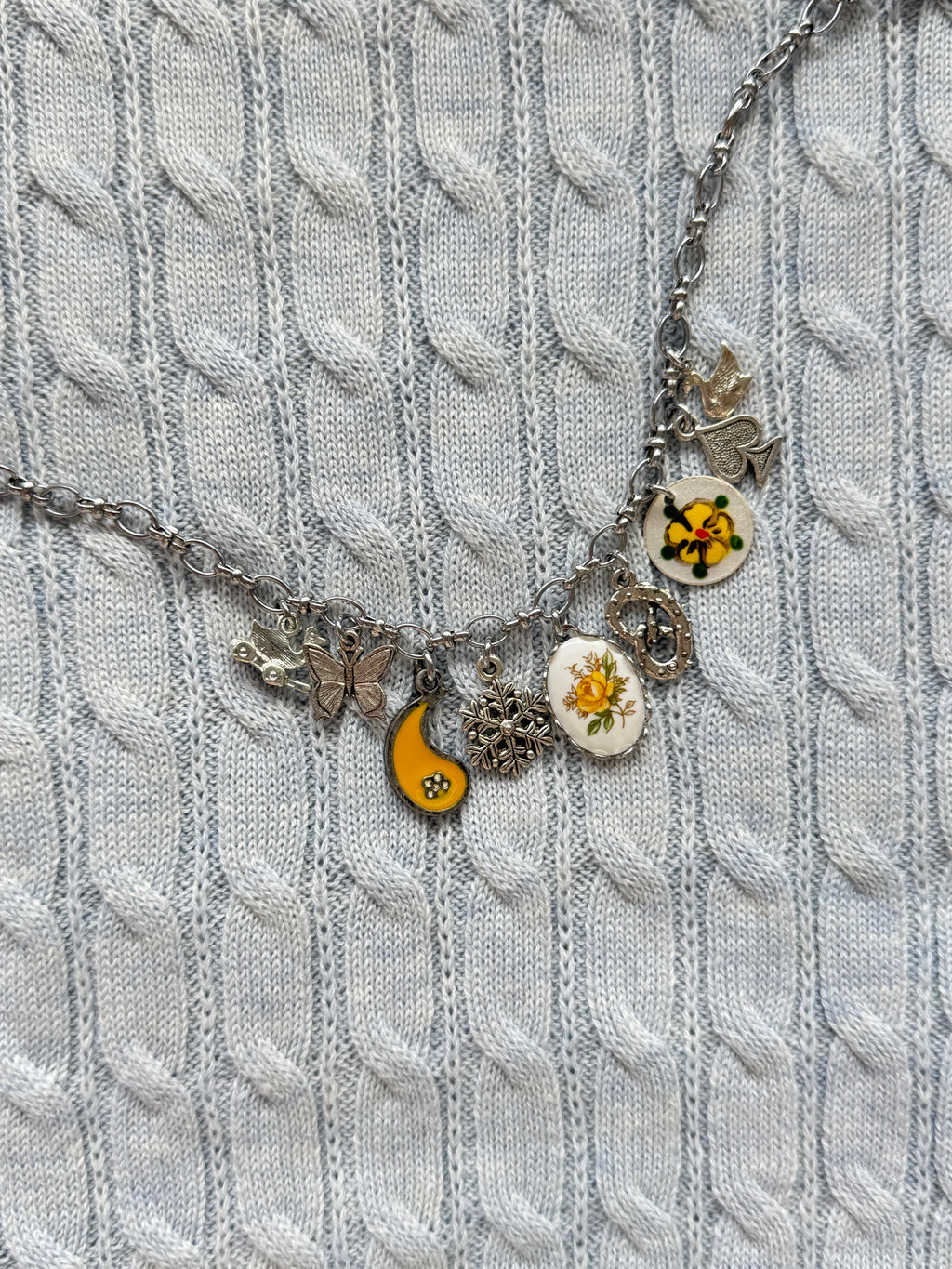 Detail of duck toy, pretzel, and butterfly charms