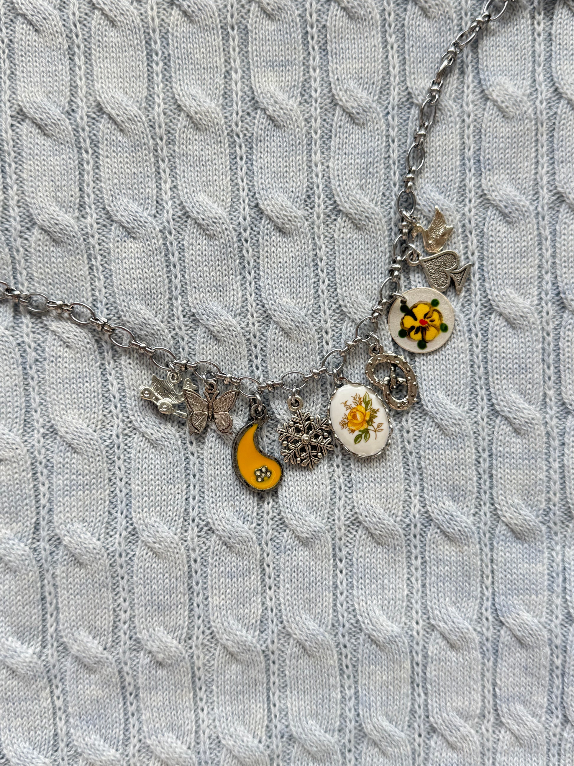 Detail of duck toy, pretzel, and butterfly charms