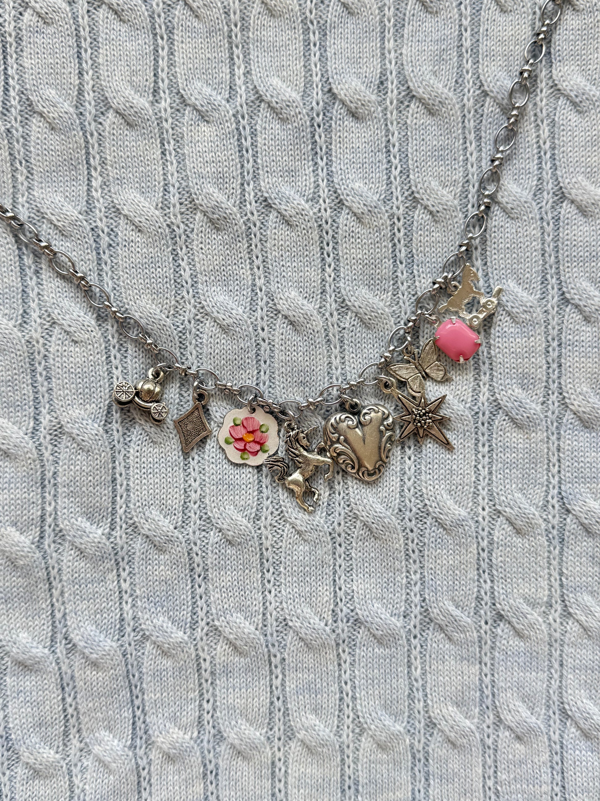 Charm detail of silver pony toy and butterfly charm