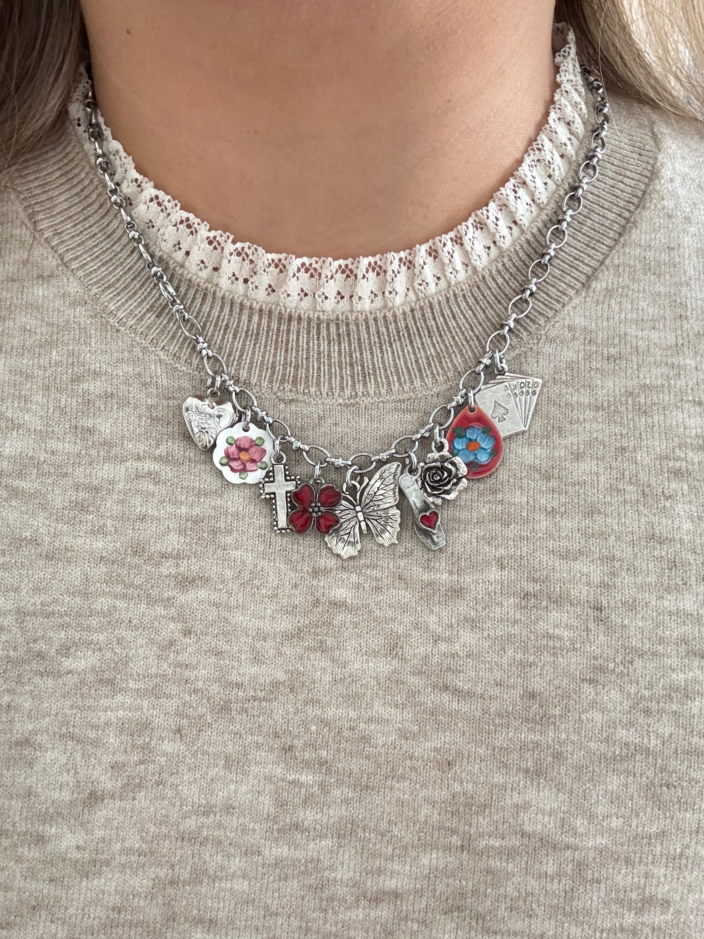 Model wearing a dainty silver charm necklace styled with a casual outfit.