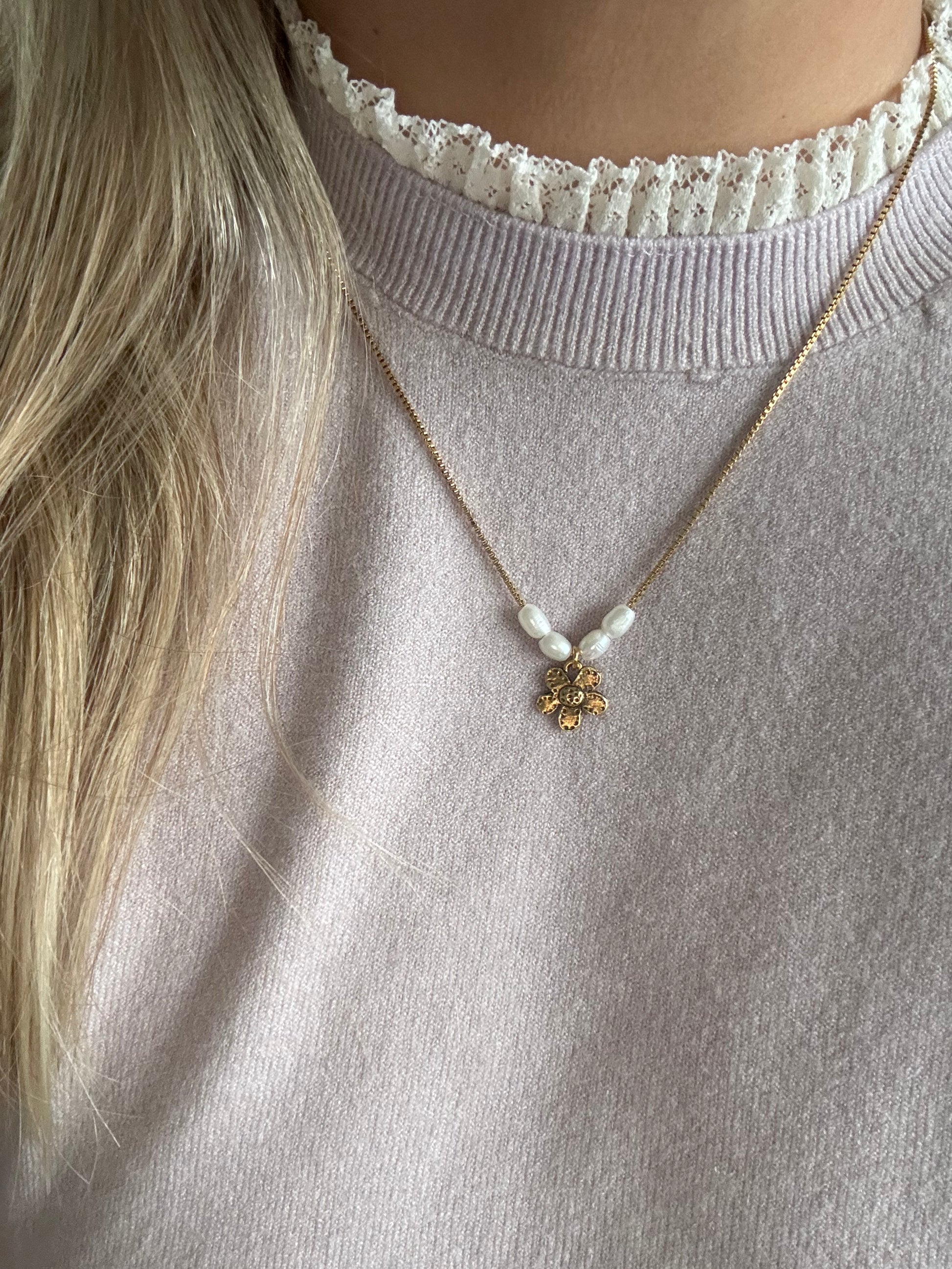 Model wearing the Margot Necklace — a delicate gold chain with freshwater pearls and a charming flower pendant, styled for a soft and feminine look.