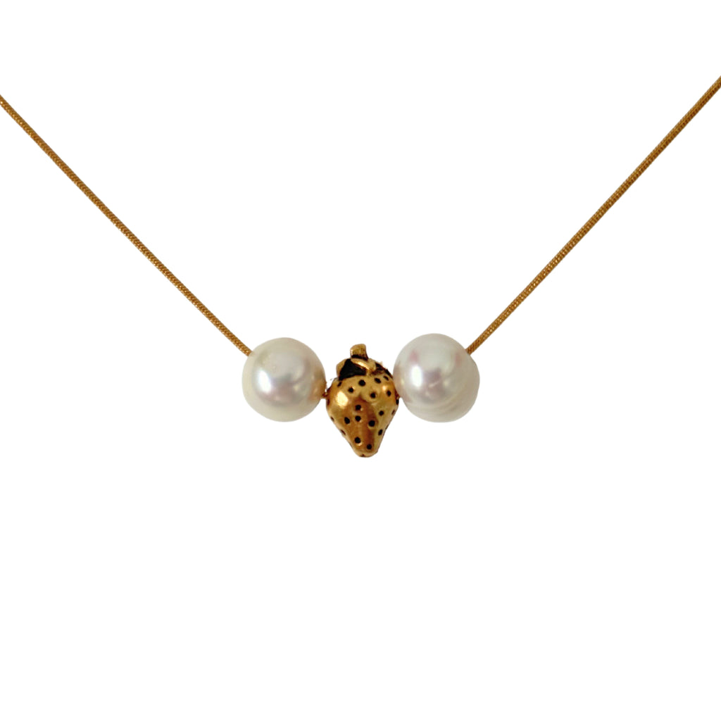 Close-up of gold strawberry charm and pearls