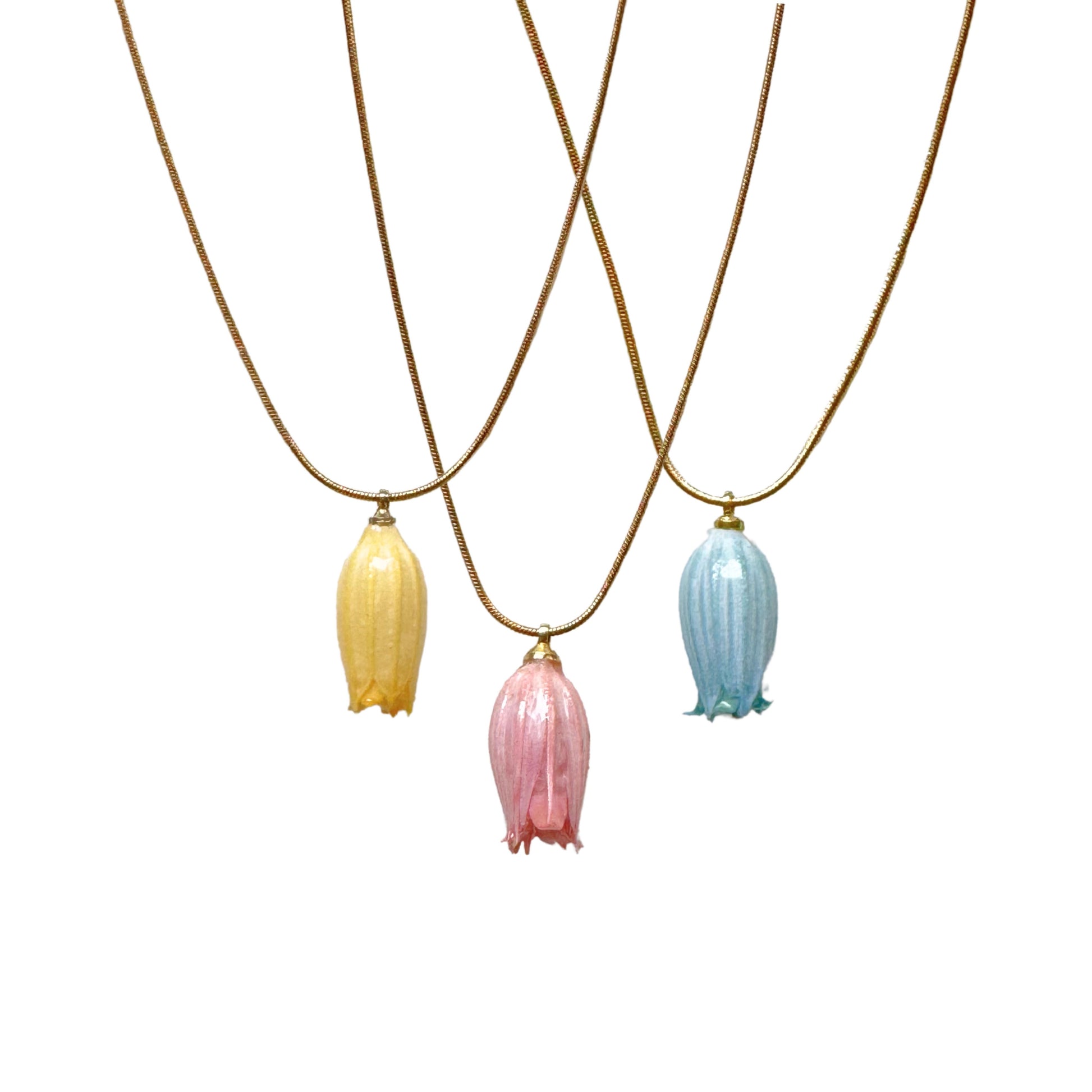 Three color options of Isla Necklace with natural floral detail