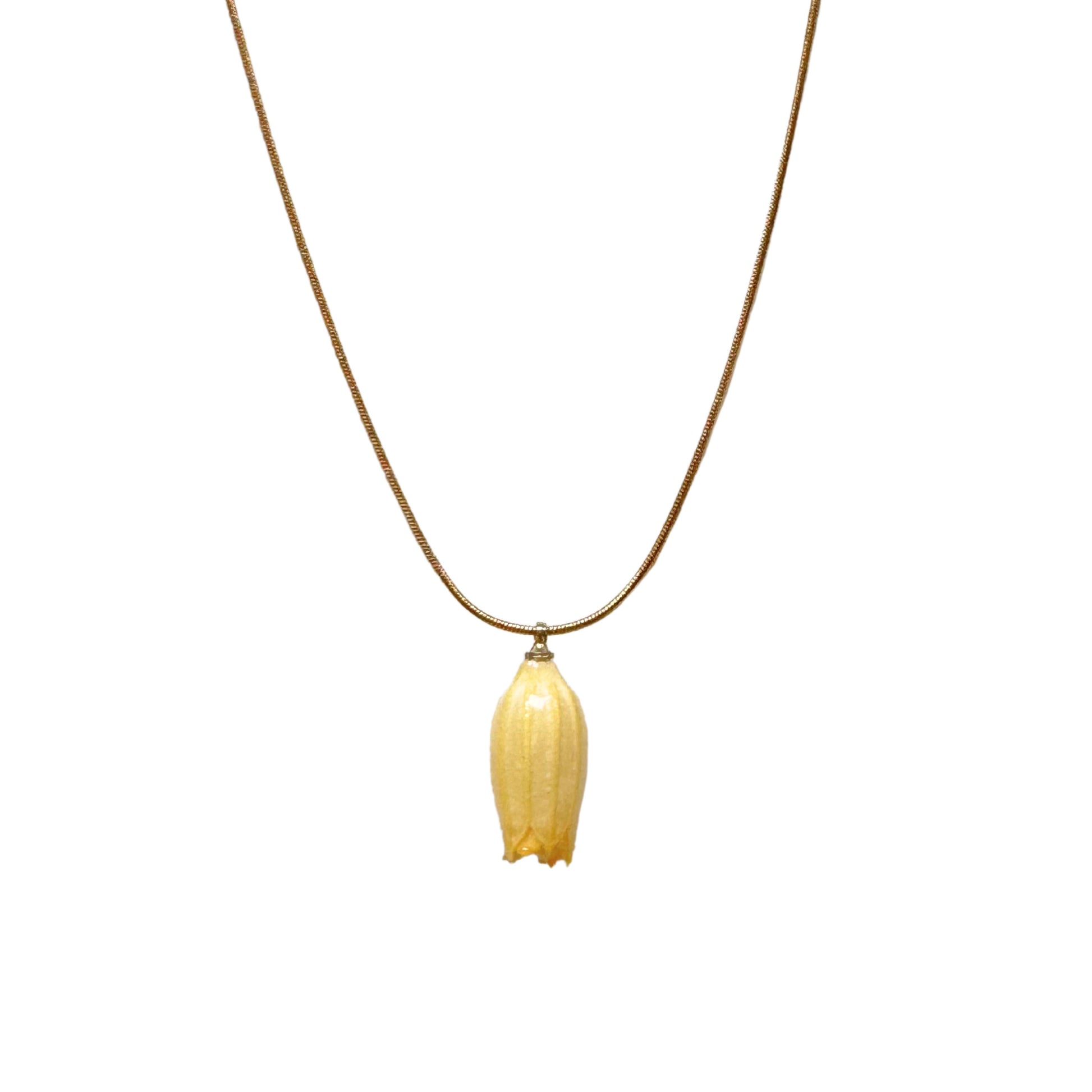 Isla Necklace flatlay with yellow flower charm