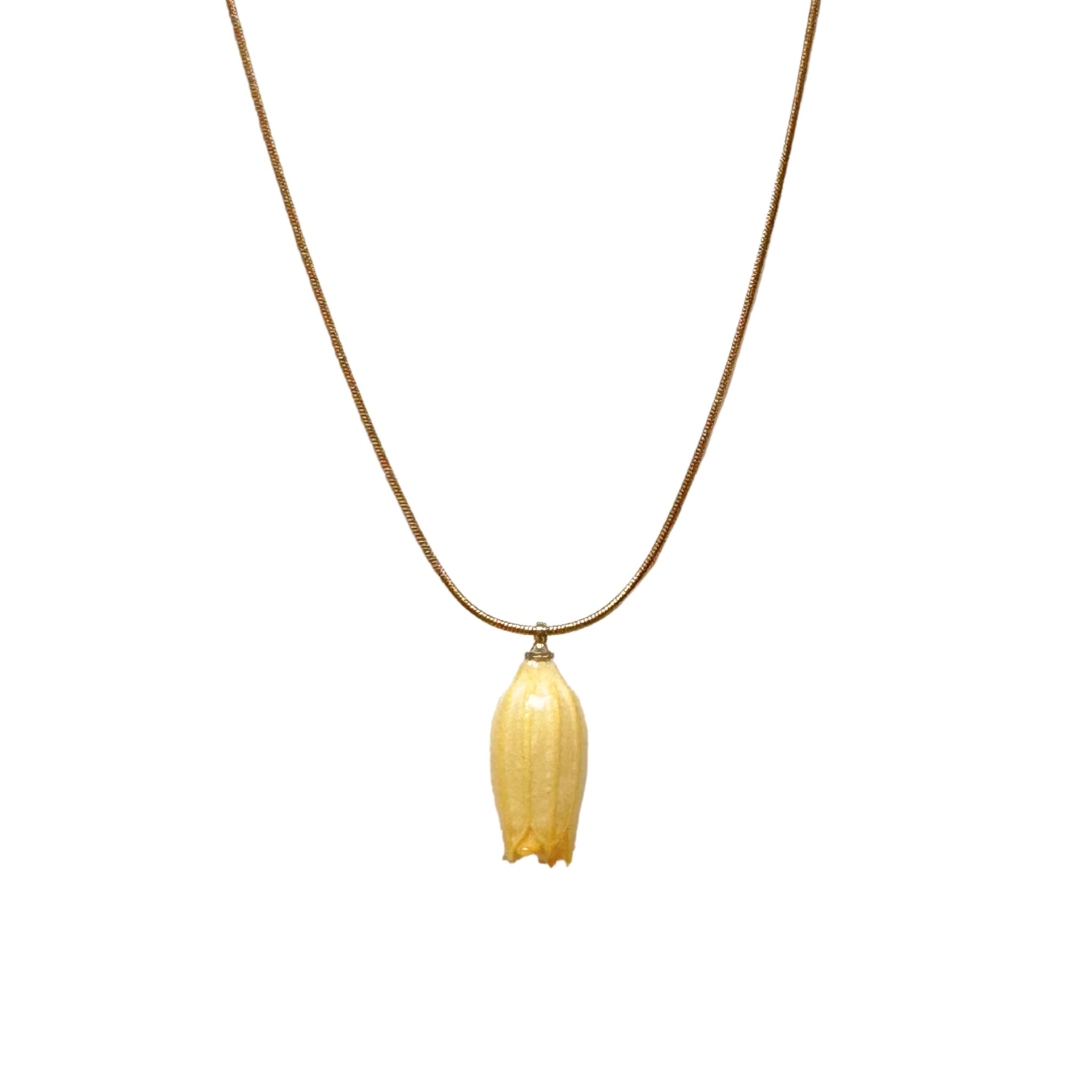 Isla Necklace flatlay with yellow flower charm