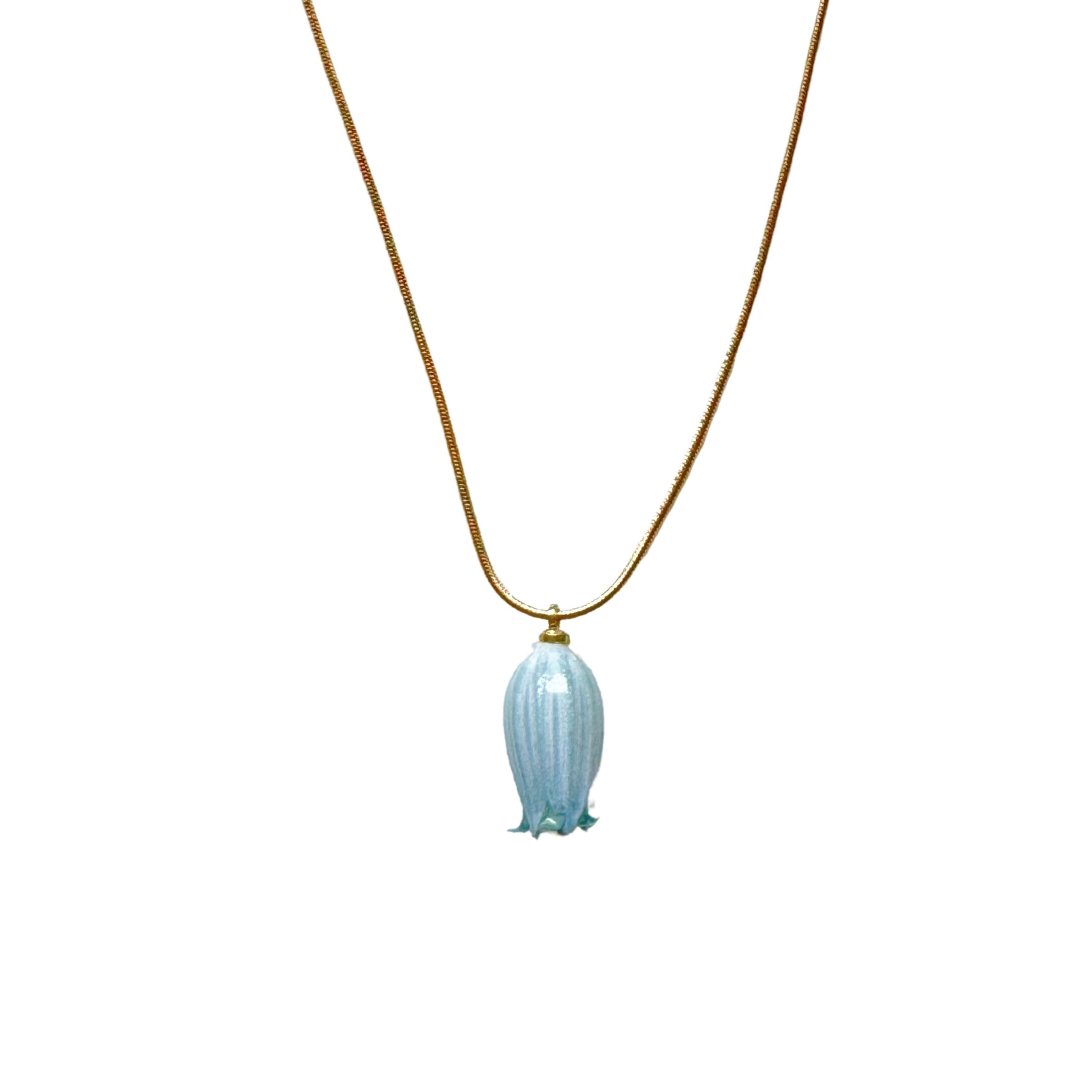Isla Necklace flatlay with blue flower charm