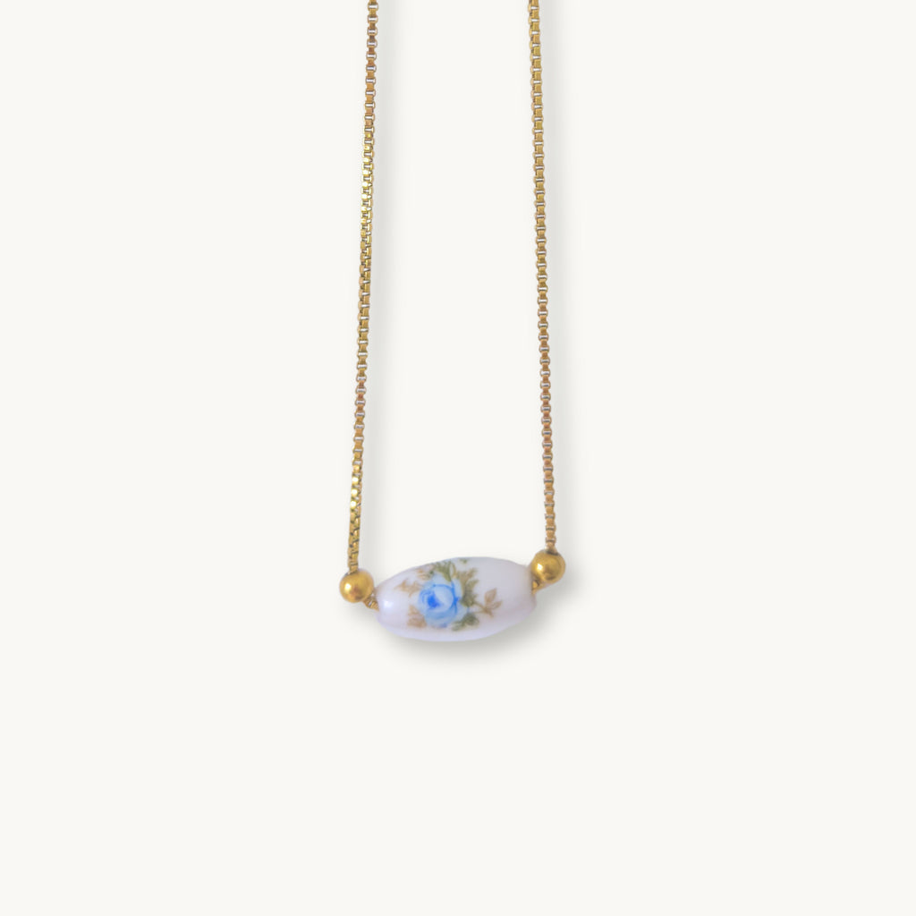 Close-up of the Lilibeth Necklace highlighting the intricate blue rose ceramic tube design.