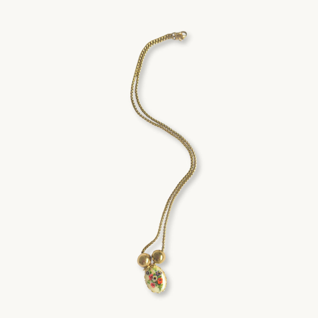 Flat-lay of the Lily Necklace on a neutral background, emphasizing its timeless charm.