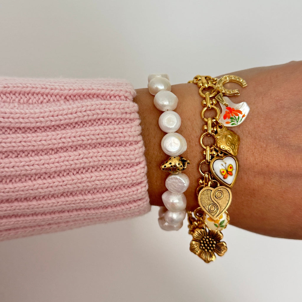 Close-up of Mandy Bracelet showing heart, horseshoe, and mother-of-pearl charm details