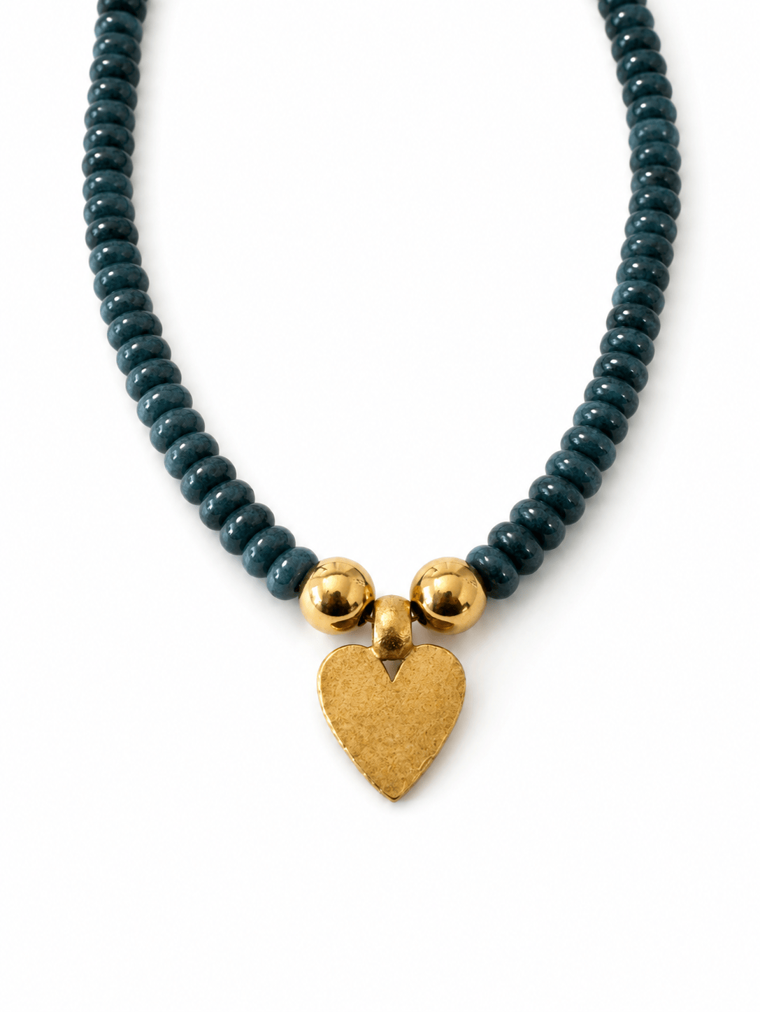 A beaded necklace featuring dark teal-green faceted beads, three polished gold spacer beads, and a textured gold heart-shaped pendant, displayed on a clean white background.