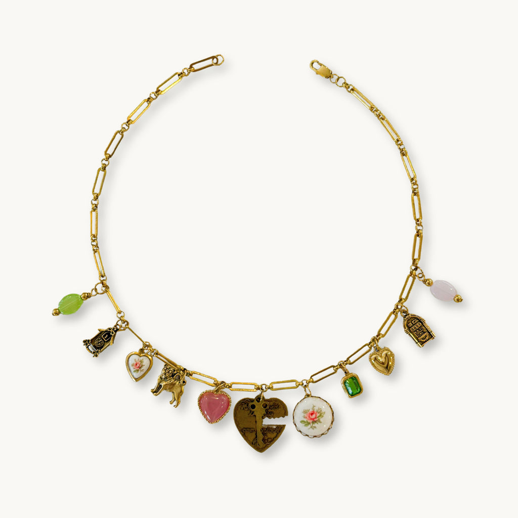 Flat-lay of the Millie Necklace with full charm view and heart & key centerpiece.
