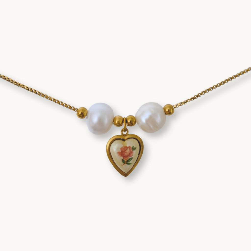 Close-up of Monica Necklace featuring lustrous baroque pearls and a vintage-inspired rose heart pendant on a gold-plated chain.