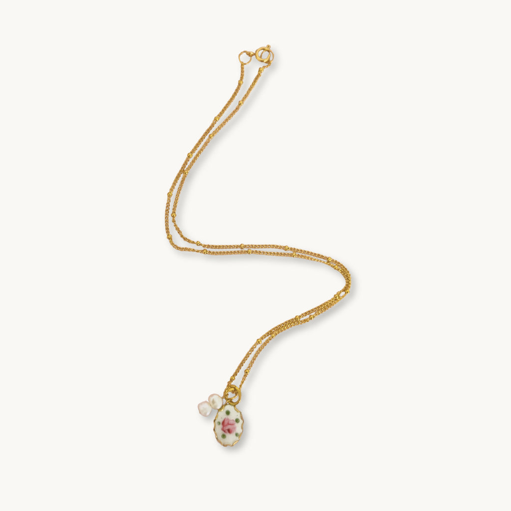 Muriel Necklace featuring a gold-plated beaded Figaro chain with a hand-painted rose pendant.
