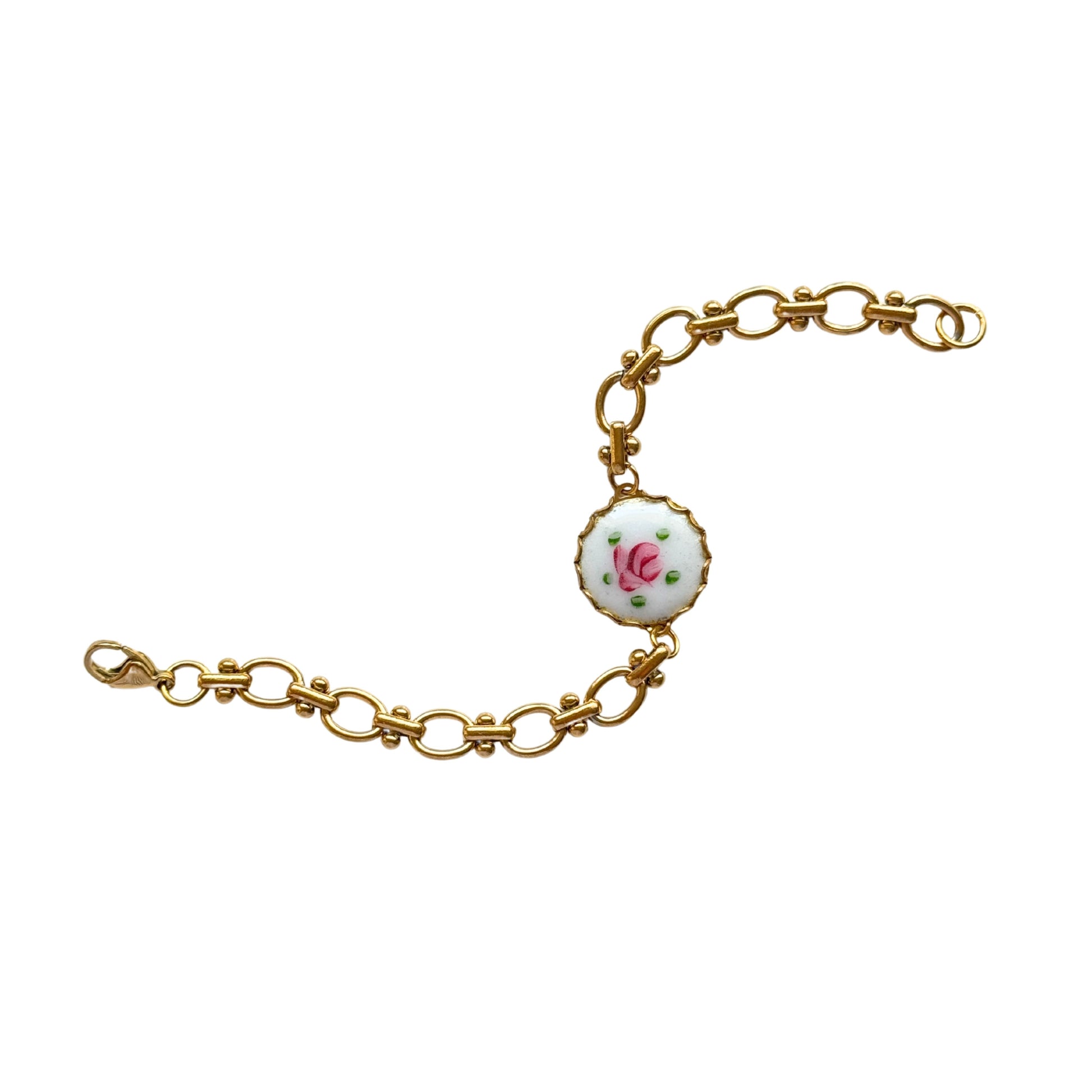 Close-up of hand-painted rose detail on brass medallion