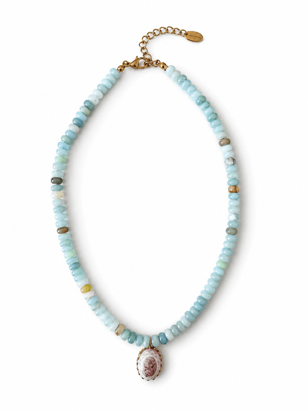 A beaded necklace featuring light blue, mint green, and white stone beads with small gold spacer beads, a gold chain extender, and a central oval pendant with a pink and white floral design.