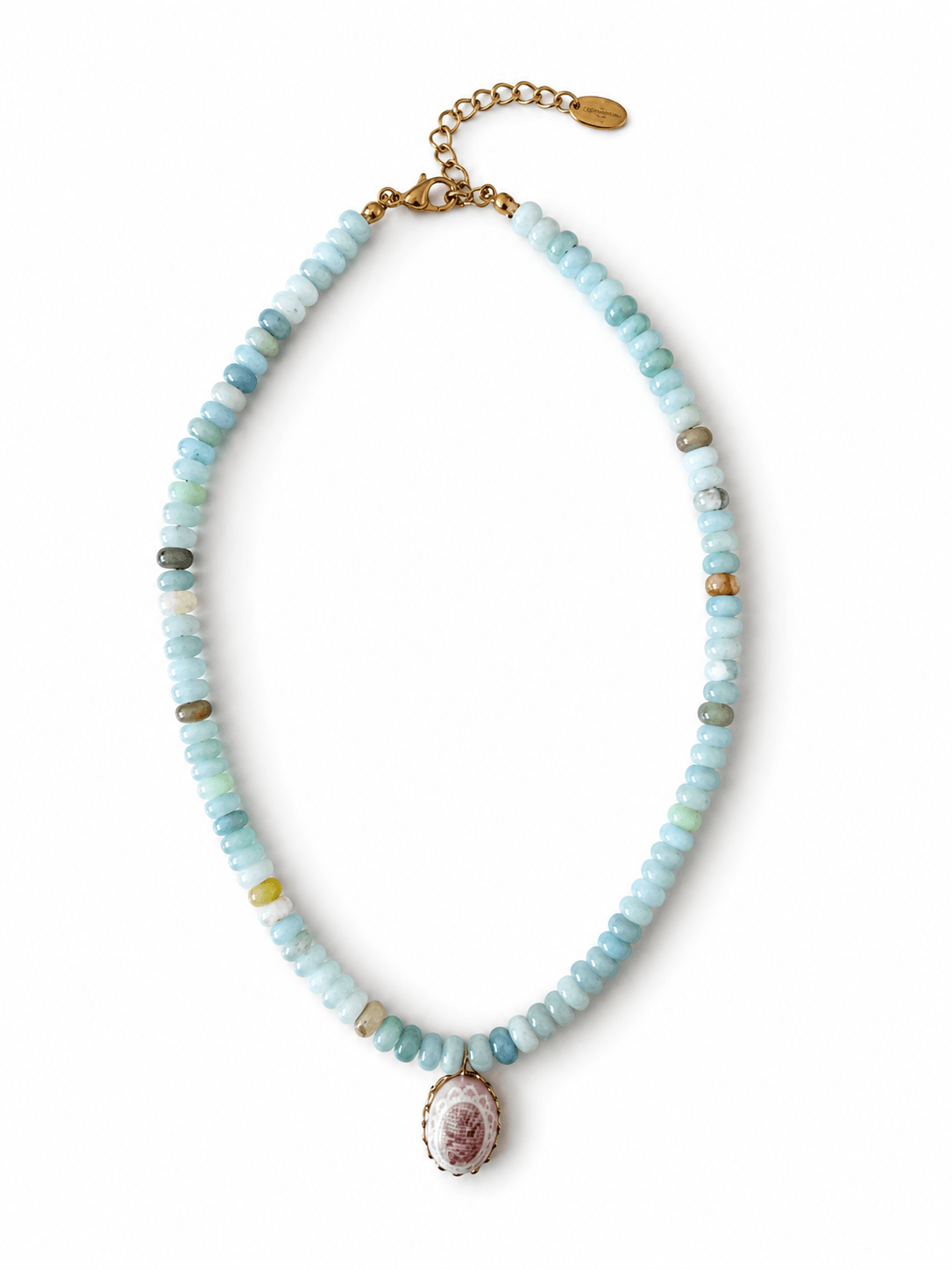 A beaded necklace featuring light blue, mint green, and white stone beads with small gold spacer beads, a gold chain extender, and a central oval pendant with a pink and white floral design.