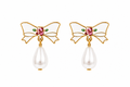 A pair of gold bow earrings with white enamel, a pink rhinestone center, small green enamel leaves, and a dangling white pearl teardrop below each bow.