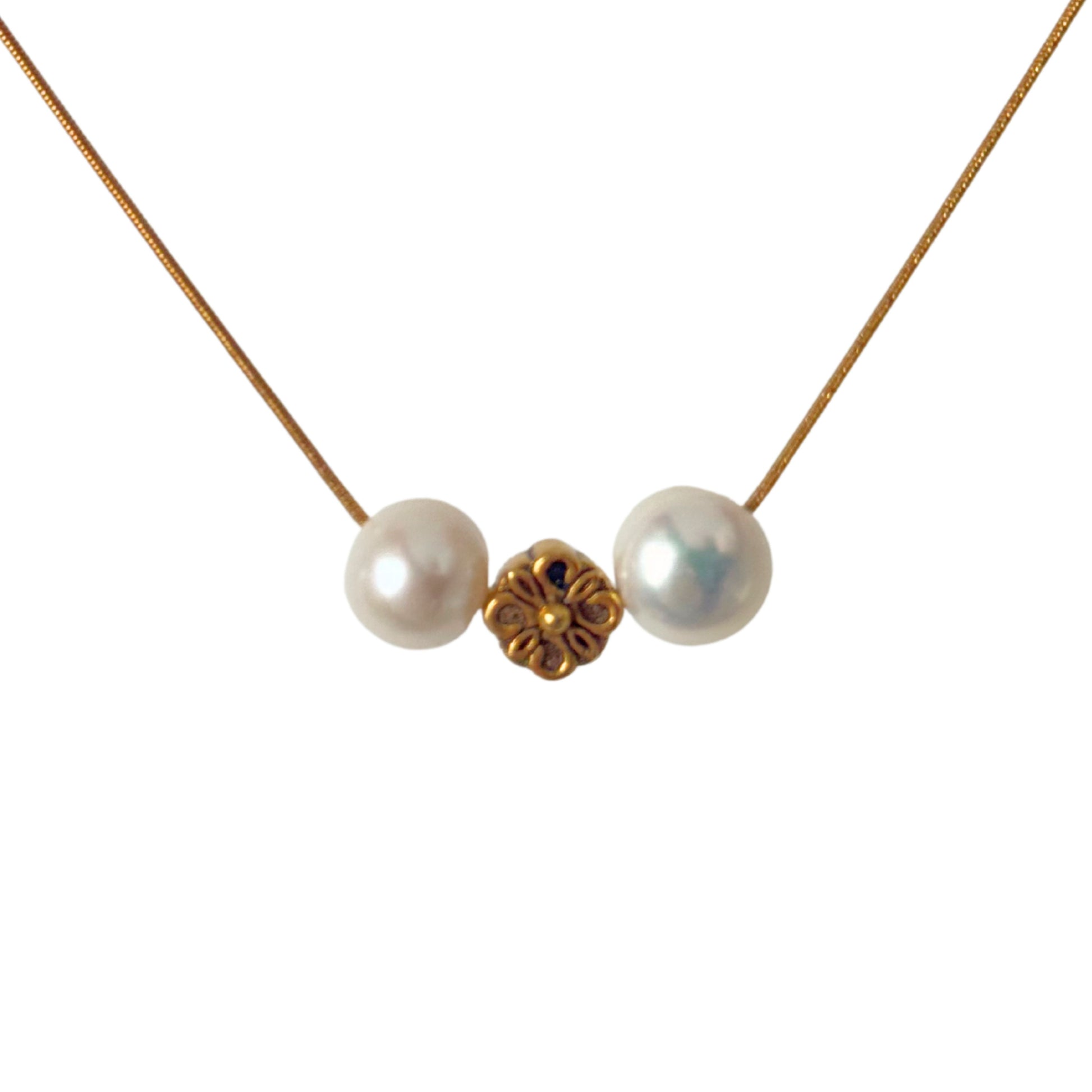 Close-up of gold flower charm and freshwater pearls