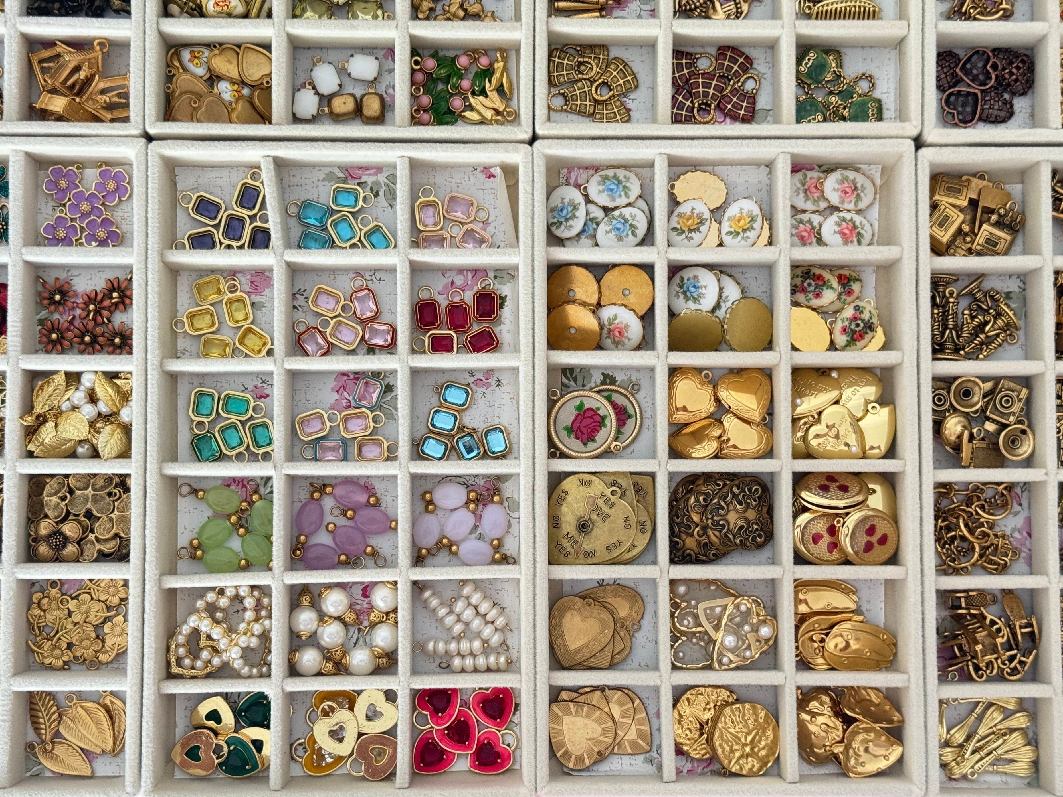Collection of various jewelry pieces in a grid display case.